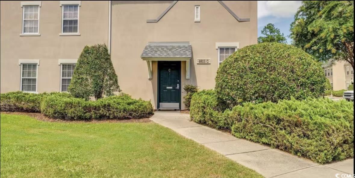 View of front facade featuring stucco siding and a front lawn