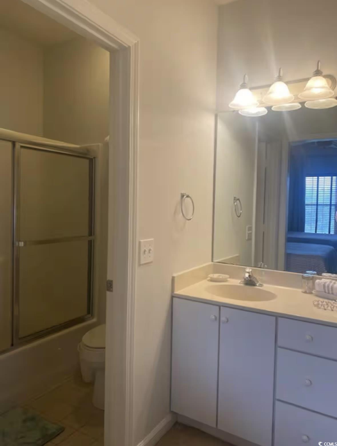 4603 Arran Court, Unit C Myrtle Beach, SC 29579 - Photo 13 of 34 Bathroom featuring bath / shower combo with glass door, toilet, tile patterned flooring, and vanity