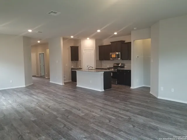 a view of kitchen with refrigerator and wooden floor