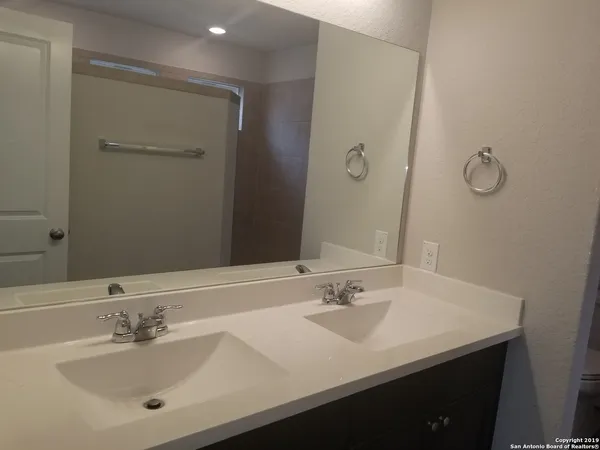 a bathroom with a double vanity sink a mirror and shower
