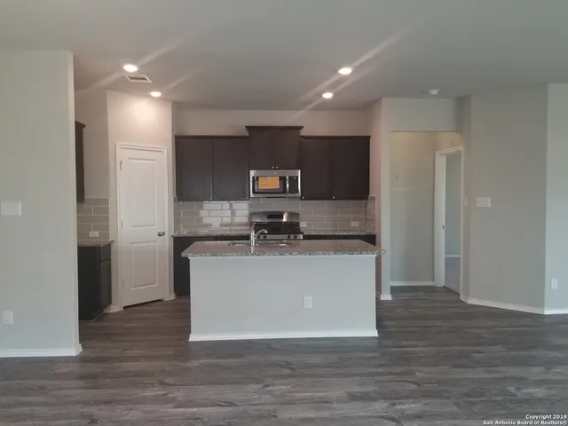 a kitchen with stainless steel appliances a refrigerator sink and microwave
