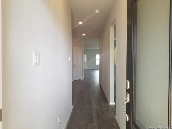 a view of a hallway with wooden floor