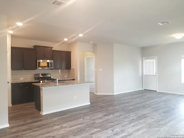 a kitchen with stainless steel appliances granite countertop a refrigerator and a stove top oven