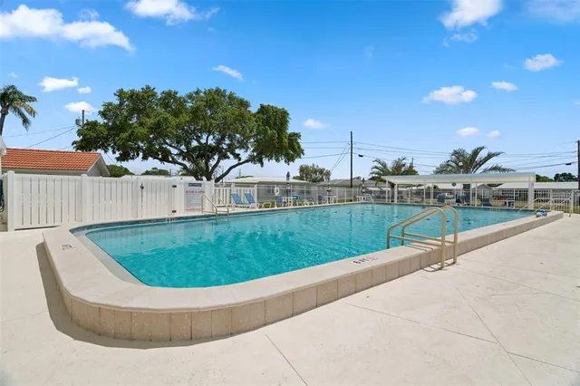 a view of a swimming pool with a yard and plants
