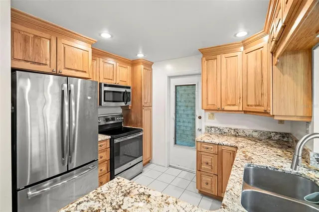 a kitchen with stainless steel appliances granite countertop a refrigerator sink and cabinets