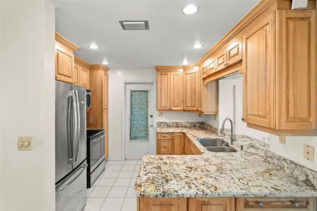 a kitchen with a refrigerator sink and cabinets