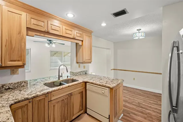 a kitchen with a sink cabinets and wooden floor