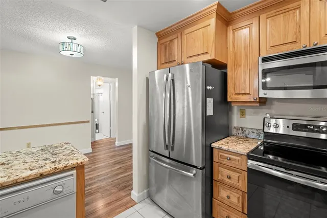 a kitchen with stainless steel appliances granite countertop a refrigerator and a stove