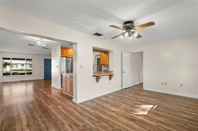 a view of a livingroom with wooden floor and a ceiling fan