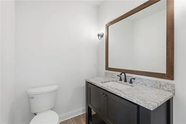 a bathroom with a granite countertop sink and a toilet