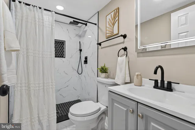 a bathroom with a sink a toilet and shower curtain