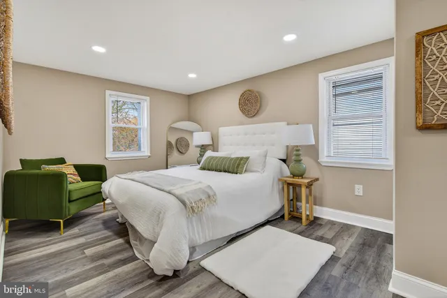 a bedroom with a bed and a dresser next to a window