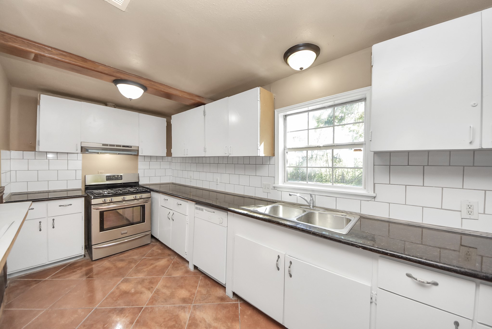 2510 Delaware Avenue League City, TX 77573 - Photo 11 of 38 a kitchen with granite countertop a sink stainless steel appliances and cabinets