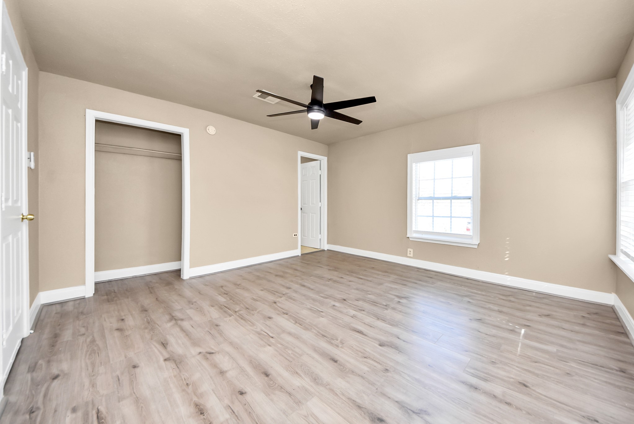2510 Delaware Avenue League City, TX 77573 - Photo 19 of 38 an empty room with wooden floor ceiling fan and windows