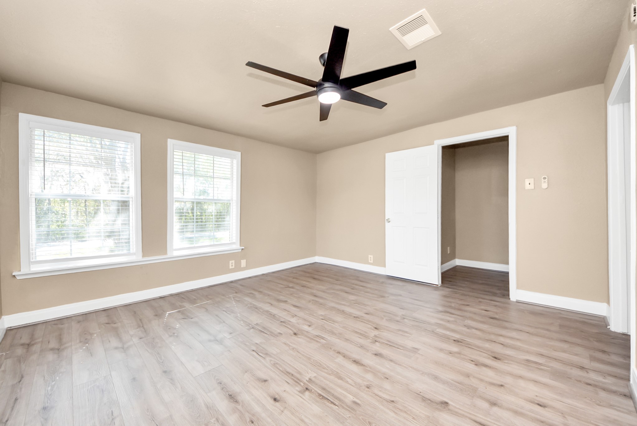 2510 Delaware Avenue League City, TX 77573 - Photo 20 of 38 an empty room with wooden floor a ceiling fan and windows