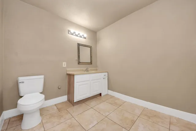 a bathroom with a toilet sink and mirror