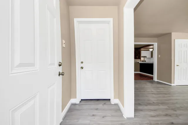 a view of a hallway with wooden floor and closet