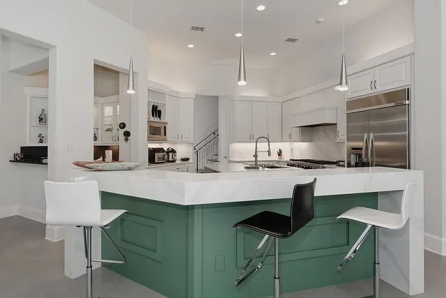a kitchen with cabinets and chairs in it