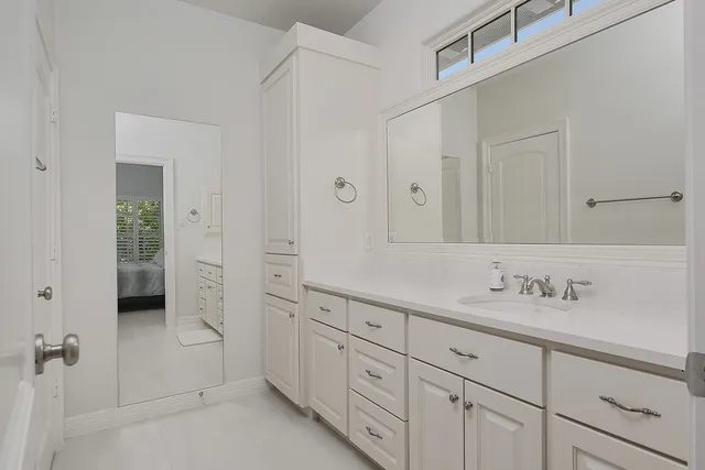 a spacious bathroom with 2 sink shower and a mirror