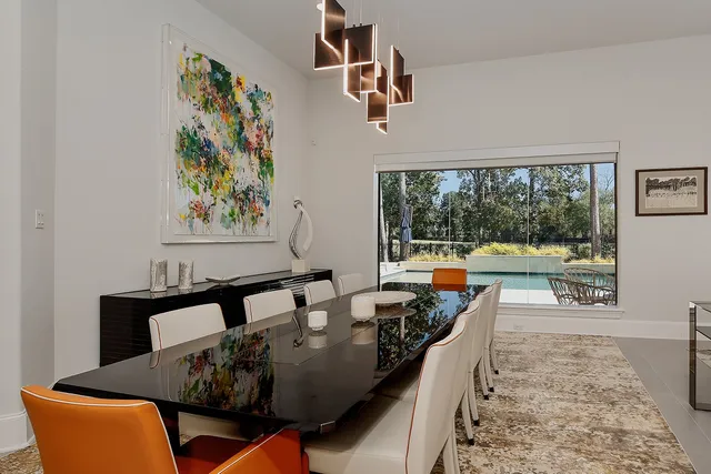a view of a dining room with furniture a chandelier and wooden floor