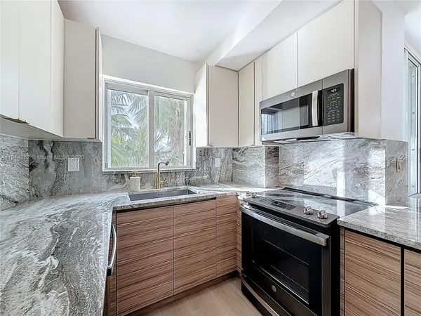 a kitchen with stainless steel appliances granite countertop a sink stove and microwave