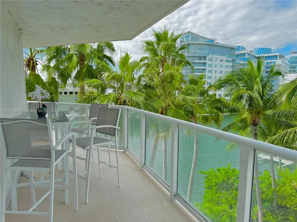 a balcony with table and chairs and a yard