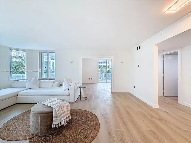 a view of a room with wooden floor and kitchen view