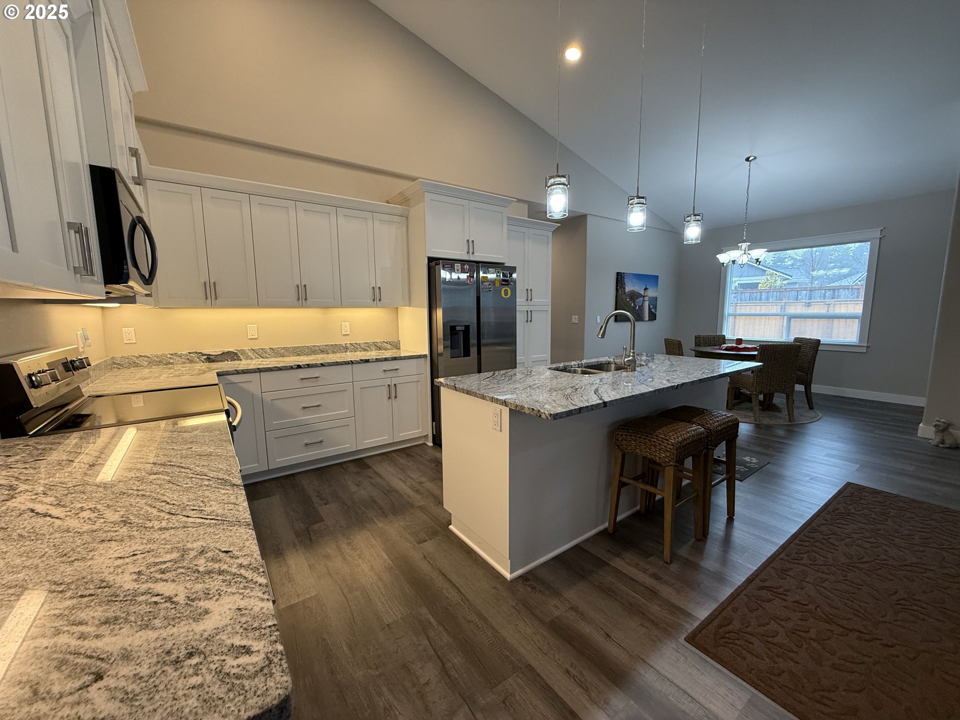 4055 Caddington Lane Florence, OR 97439 - Photo 22 of 48 a large kitchen with kitchen island a island a stove a sink a counter space and cabinets