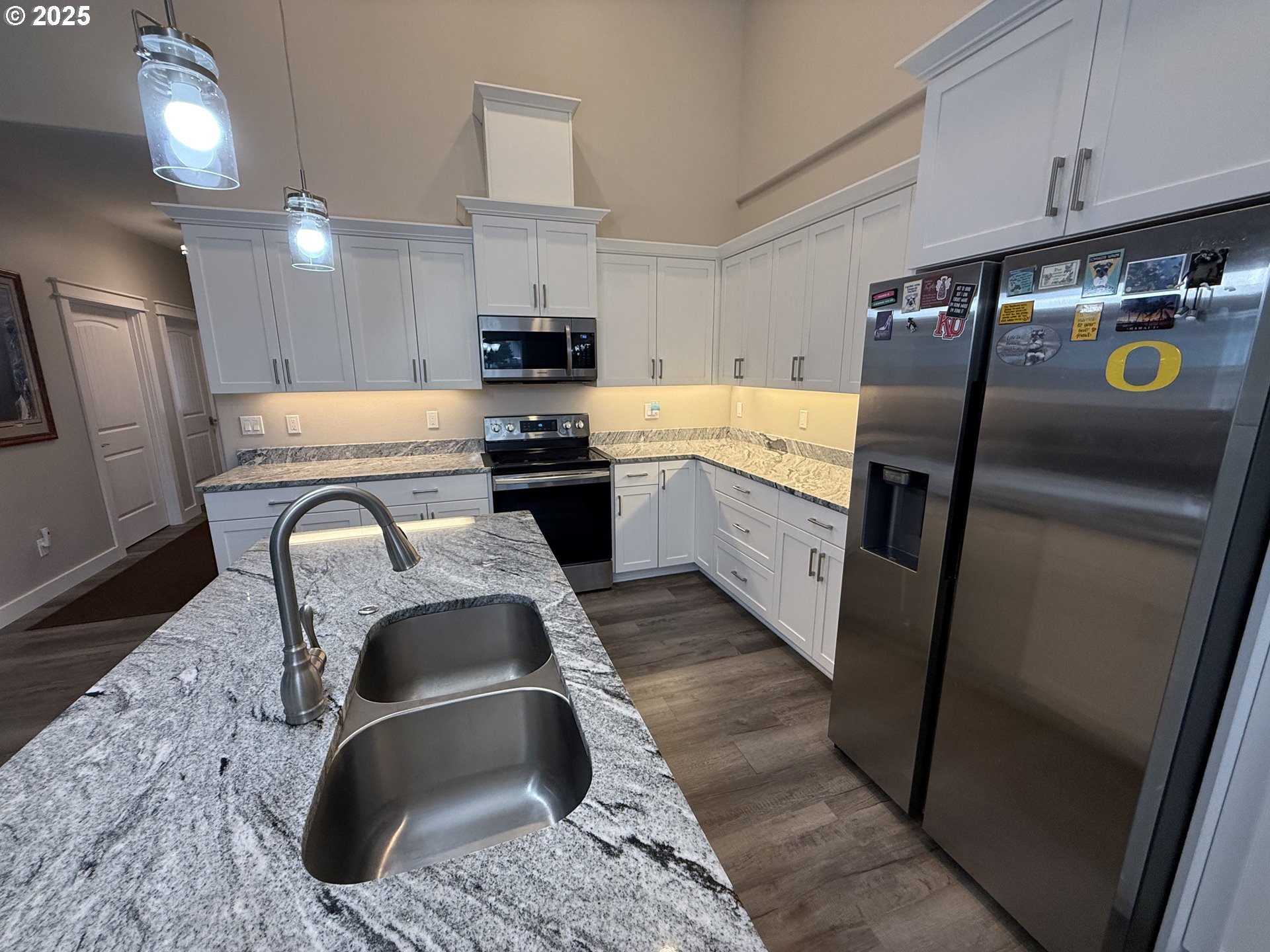 4055 Caddington Lane Florence, OR 97439 - Photo 23 of 48 a kitchen with stainless steel appliances granite countertop a sink a stove top oven a refrigerator a washer and dryer