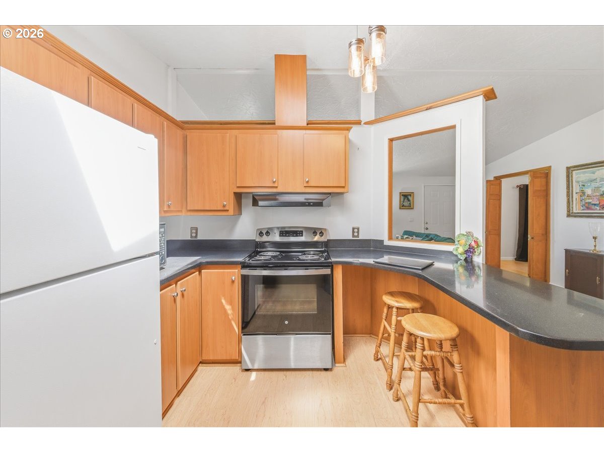 475 East 9th Street Rainier, OR 97048 - Photo 11 of 43 a kitchen with stainless steel appliances granite countertop a stove a sink and a refrigerator