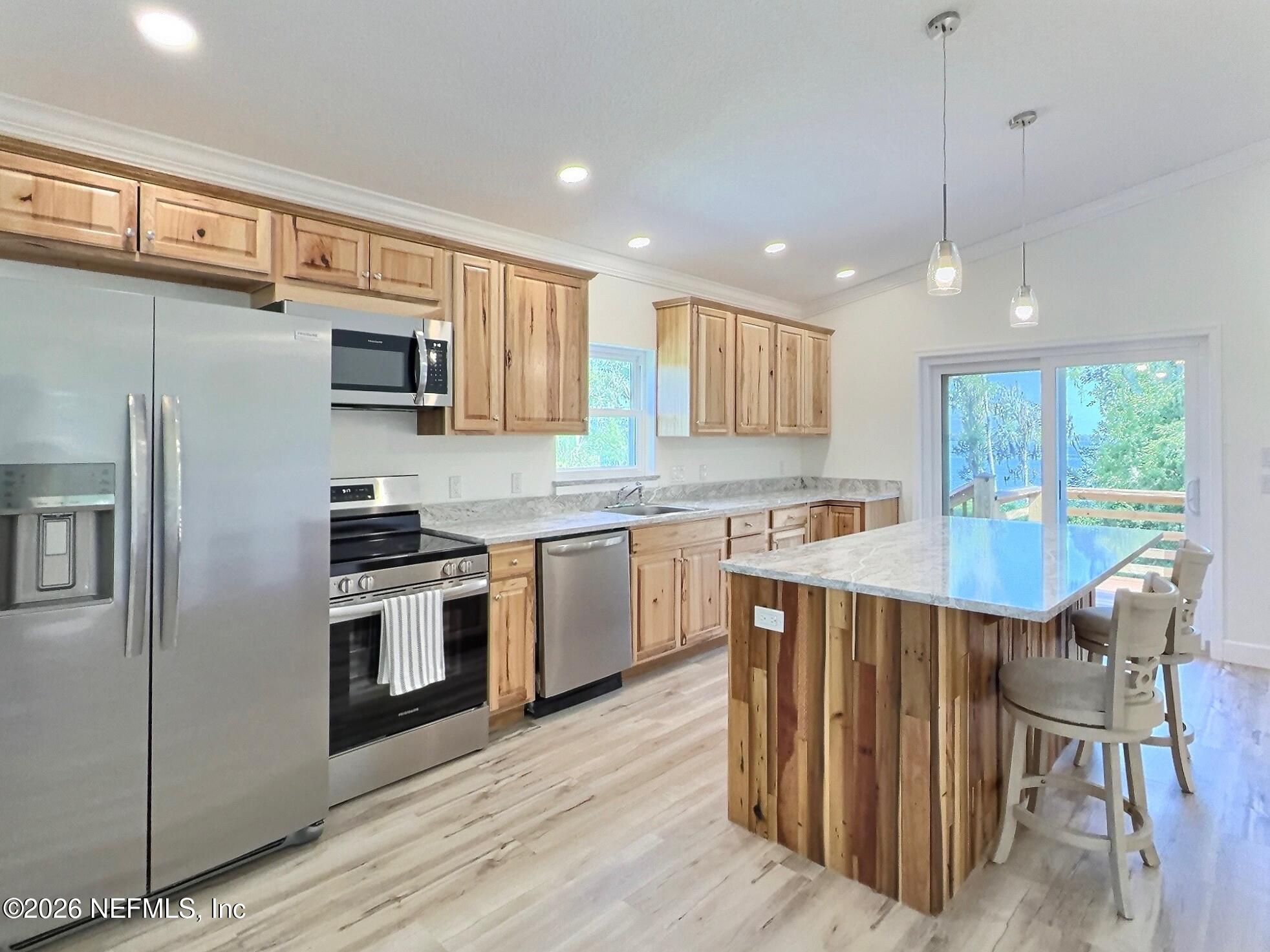 159 Mays Cove Road East Palatka, FL 32131 - Photo 47 of 62 a kitchen with kitchen island granite countertop a stove a sink a oven a dining table and chairs