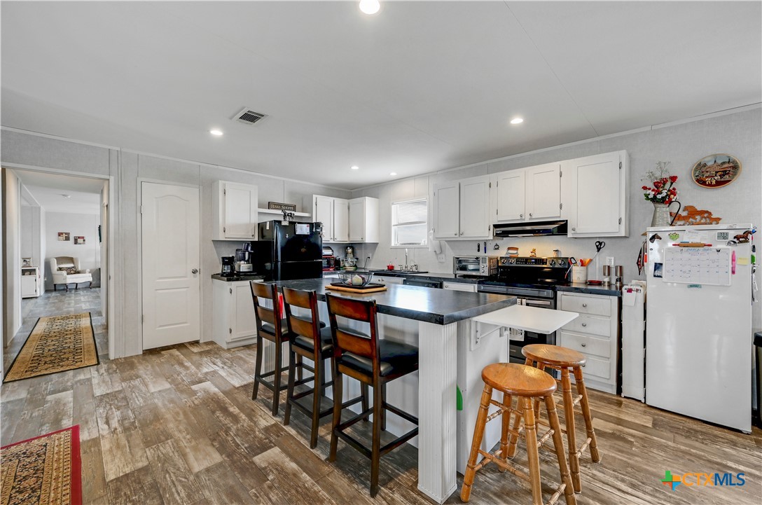 2283 Schwab Road Seguin, TX 78155 - Photo 23 of 40 a kitchen with stainless steel appliances a microwave a stove a table and chairs