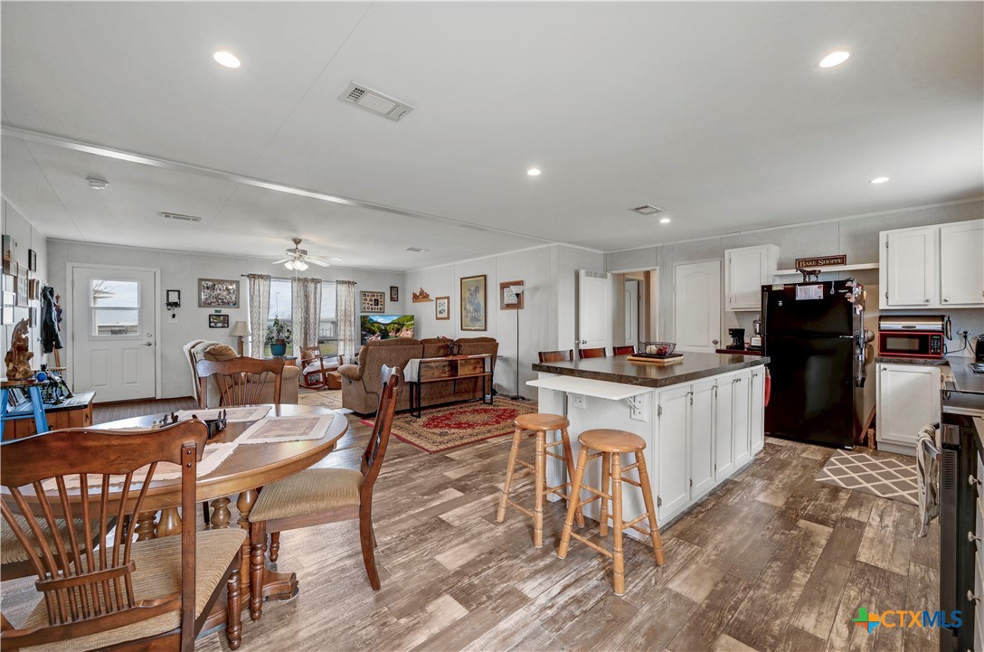 2283 Schwab Road Seguin, TX 78155 - Photo 24 of 40 a kitchen with stainless steel appliances kitchen island granite countertop a refrigerator a stove a sink a dining table and chairs with wooden floor