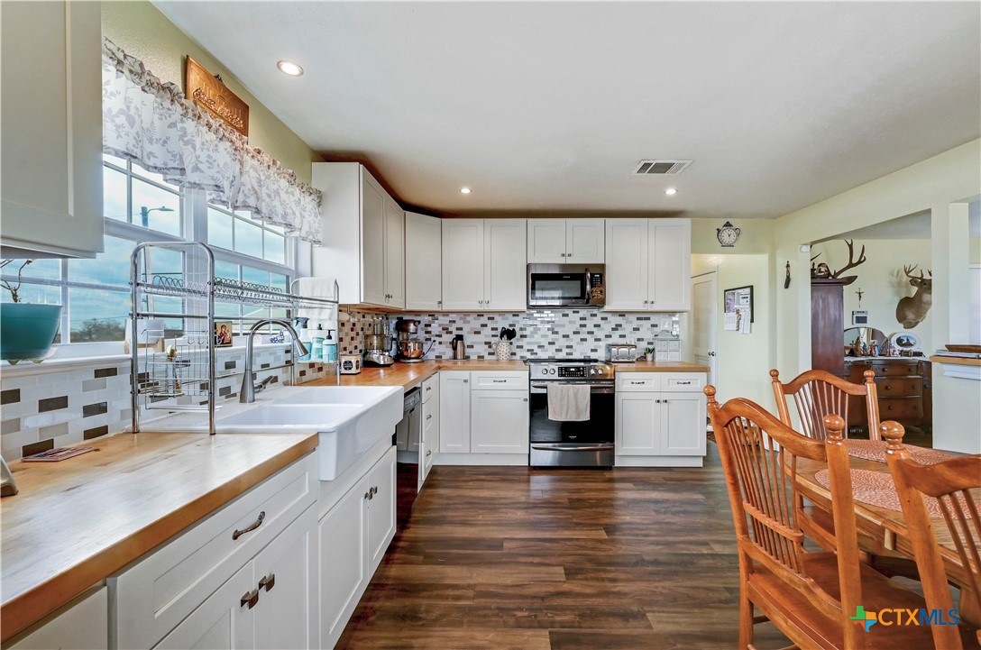 2283 Schwab Road Seguin, TX 78155 - Photo 8 of 40 a large kitchen with stainless steel appliances kitchen island granite countertop a sink and cabinets