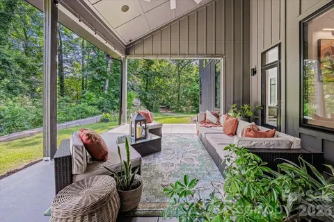 a view of a patio with couches chairs potted plants and a palm tree