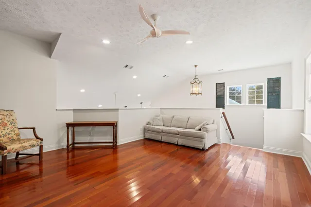 a view of a big room with wooden floor and windows