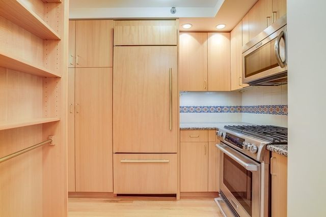 a kitchen with stainless steel appliances a refrigerator a stove a microwave and cabinets