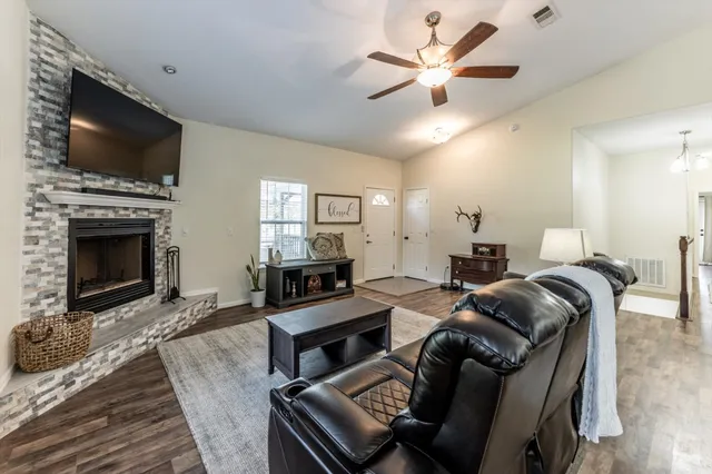 a living room with furniture a fireplace and a flat screen tv