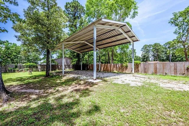 a view of a backyard with table and chairs under an umbrella
