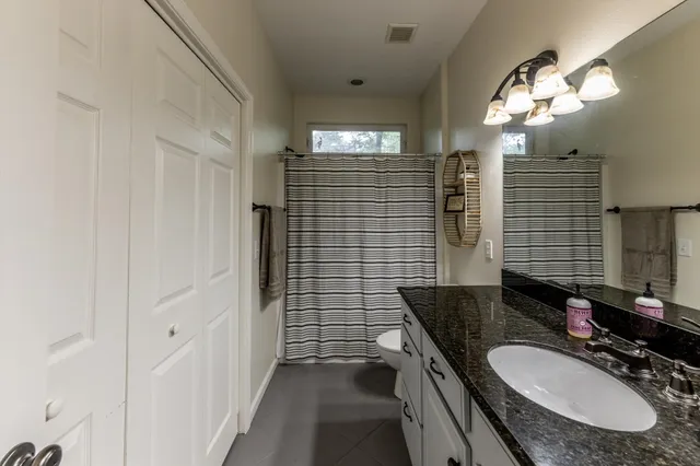 a bathroom with a sink a vanity a mirror and a shower