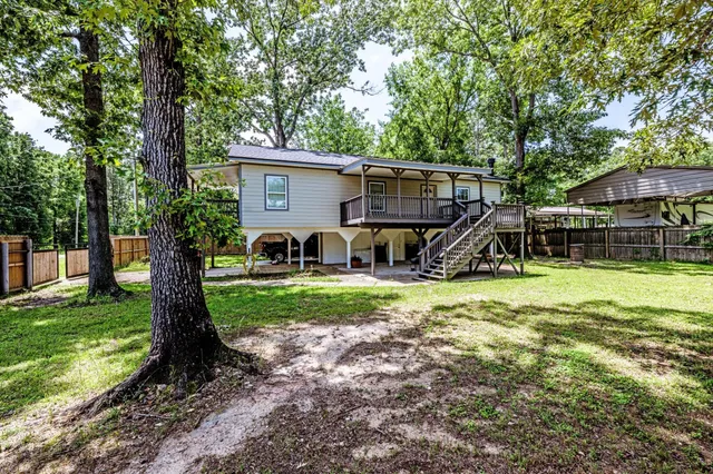 a view of a house with backyard and a tree