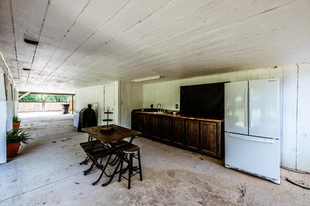 a living room with furniture a flat screen tv and kitchen view
