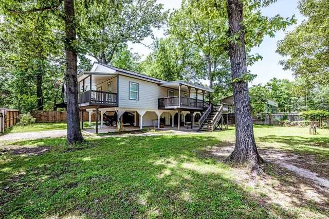 a view of a house with backyard and a tree