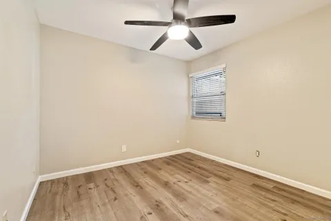 an empty room with a window and a ceiling fan