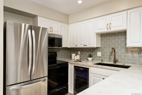 a kitchen with refrigerator a microwave a sink and cabinets