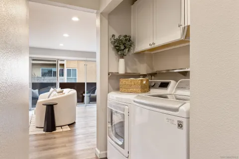 a view of washer and dryer with kitchen in the background