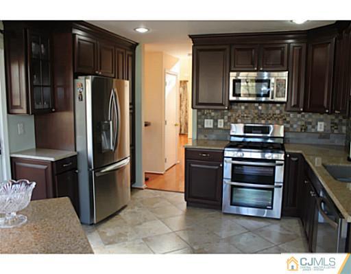 78 Springfield Road North Brunswick, NJ 08902 - Photo 5 of 19 a kitchen with kitchen island wooden cabinets and stainless steel appliances
