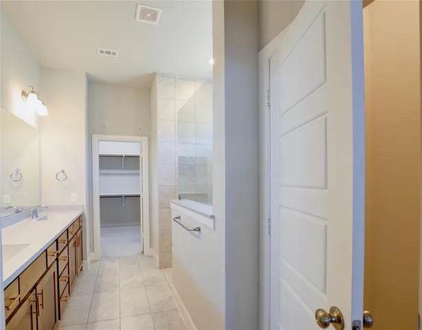 a spacious bathroom with a double vanity sink and a mirror
