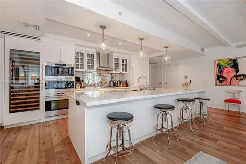 a kitchen with stainless steel appliances granite countertop a stove a sink dishwasher and a refrigerator with wooden floor