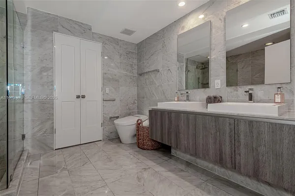 a bathroom with a sink a toilet and shower